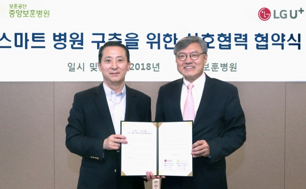 권영수 LG유플러스 부회장(왼쪽)과 이정열 중앙보훈병원장(오른쪽)이 업무협약을 체결하고 있다.