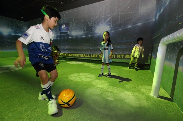 KT가 롯데백화점 부천 중동점에 오픈한 ‘케이-라이브 엑스’에서 아이들이 ‘MR풋볼’을 즐기고 있다.