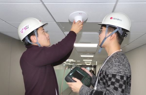 LG유플러스 직원들이 신축 건물에 5G 인빌딩 안테나를 설치하고 있다.