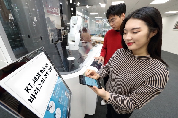 KT 모델들이 서초구 삼성생명에 위치한 세계 최초의 5G 로봇 카페 ‘비트’에서 바리스타 로봇이 제조한 커피를 들고 촬영을 하고 있다.