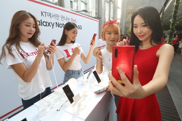 19일 노보텔 앰배서더 서울 동대문에서 열린 ‘갤럭시 노트10 5G’ 출시 기념 론칭 파티에서 모델들이 KT 전용 ‘아우라 레드’ 색상의 갤럭시 노트10 5G를 보고 있다.