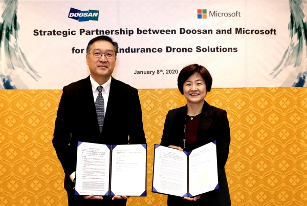 이두순 두산모빌리티이노베이션 대표(왼쪽)와 우미영 한국마이크로소프트 부사장이 파트너십을 체결하고 있다.