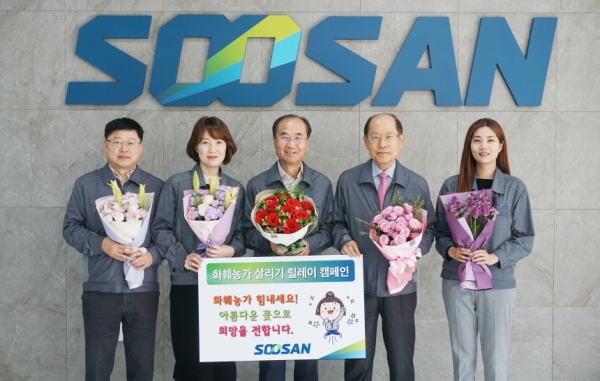 수산그룹 정석현 회장(가운데)과 임직원들이 ‘플라워 버킷 챌린지 캠페인’에 참여하고 포즈를 취하고 있다.