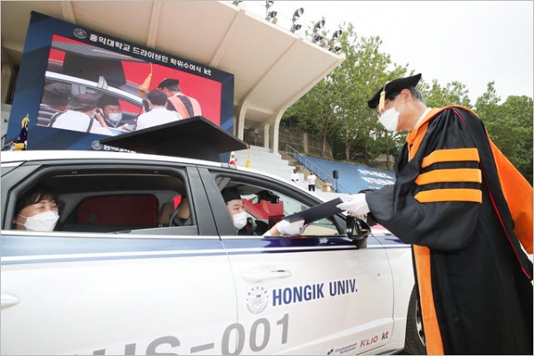 졸업생이 차량에 탑승한 상태로 드라이브 스루(Drive-Thru) 비접촉 형식의 졸업장 수여식을 진행하고 있다.