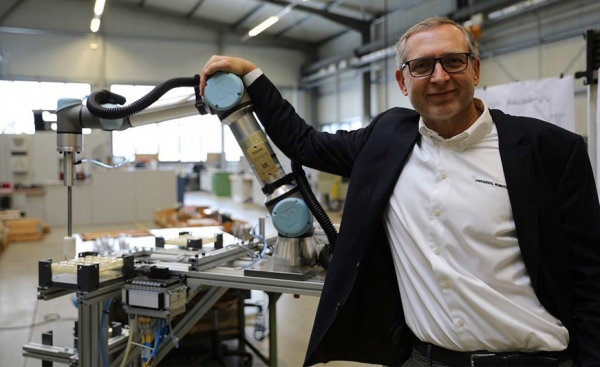 요르겐 본 홀렌 유니버설로봇 대표가 5만번째 판매된 UR 로봇과 기념촬영을 하고 있다.