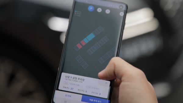 LG유플러스 관계자가 모바일 앱을 통해 5G 자율주행차 'A1'을 인근 주차장 빈 자리로 자율주차 보내고 있다.