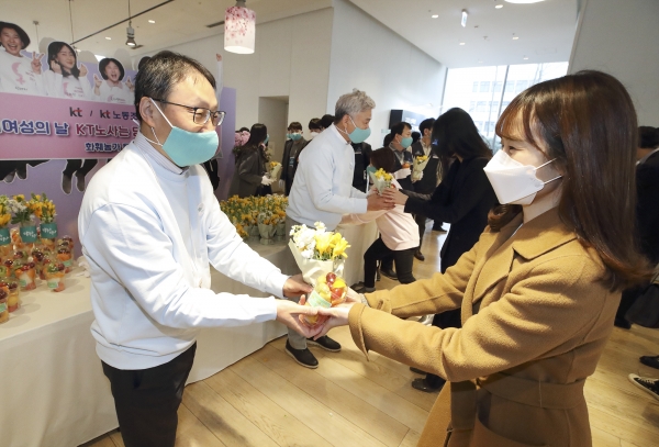 (왼쪽부터)KT 구현모 대표와 최장복 노조위원장이 광화문에 위치한 KT 이스트 사옥에서 여성 임직원에게 꽃을 나눠주고 있다.