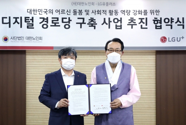 LG유플러스 최택진 기업부문장(왼쪽)과 대한노인회 김호일 회장이 업무협약을 체결한 후 기념촬영을 하고 있다.