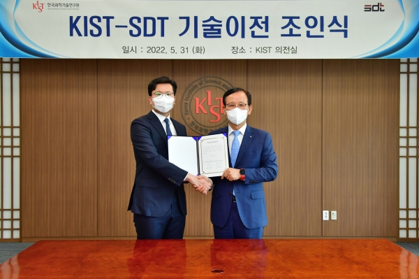 윤지원 에스디티 대표(왼쪽)와 윤석진 KIST 원장이 기술이전 조인서에 서명을 한 후 기념촬영을 하고 있다.