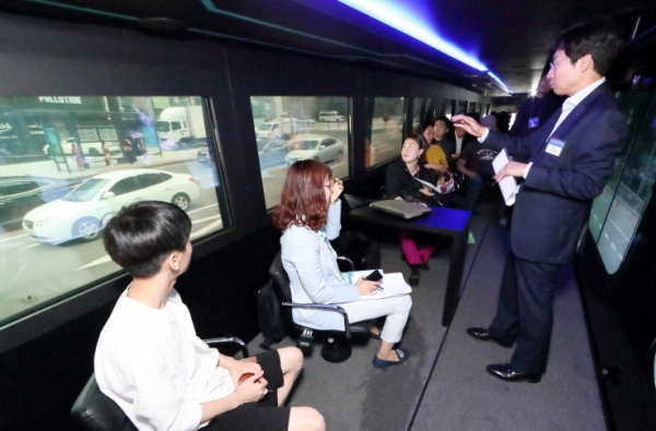 김현미(우측 첫 번째) 국토교통부 장관이 KT 자율주행 버스에 탑승해 ‘협력 자율주행’ 기술에 대해 설명 듣고 있다.