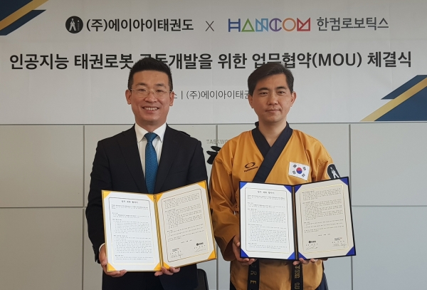 전동욱 한컴로보틱스 대표(왼쪽)와 최중구 에이아이태권도 대표가 업무협약을 체결하고 기념촬영을 하고 있다.