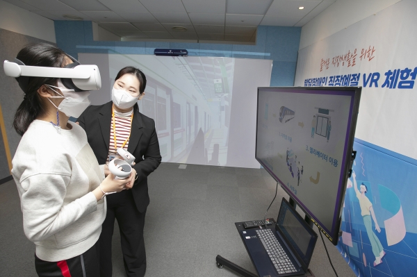 발달장애인이 VR기계를 쓰고 가상환경에서 직장생활을 체험하고 있다.