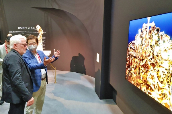 서울 코엑스에서 열린 세계 3대 아트페어 중 하나인 프리즈에서 박형세 HE사업본부장(오른쪽)과 배리엑스볼 작가가 올레드 TV로 구현한 NFT 작품을 살펴보고 있다.